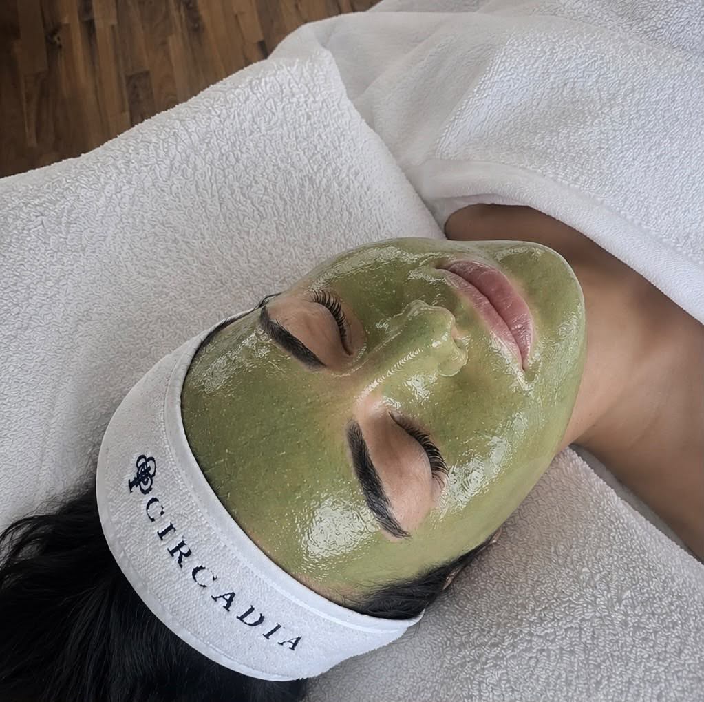 Kundin auf der Behandlungsliege mit einer grünen Wirkstoffmaske im Gesicht und einem Circadia Stirnband